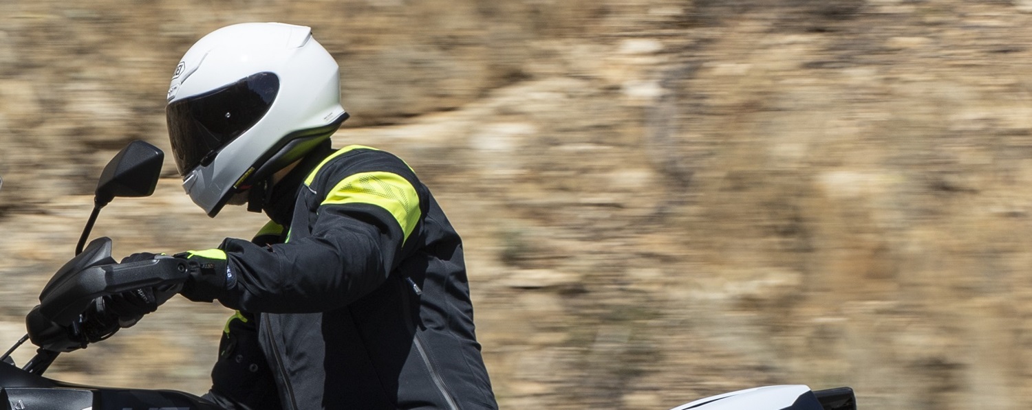 rider on a motorcycle wearing a black and yellow jacket