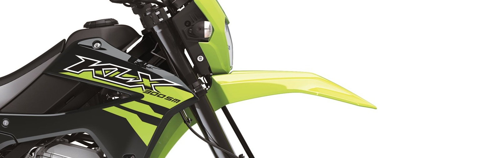 close view of headlight, tank, radiator shroud of a Kawasaki KLX300SM in a studio photo