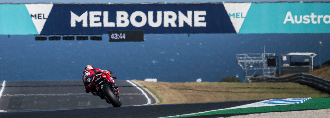 race motorcycle heading toward the ocean on the Phillip Island Grand Prix Circuit under a Melbourne Australia banner