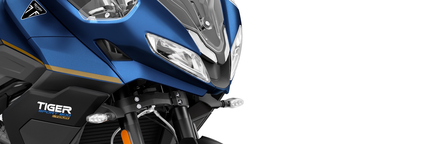 Close view of a studio photo of the front fairing, headlights and "Tiger Sport" logo on the blue Tiger Sport 800 Tour motorcycle